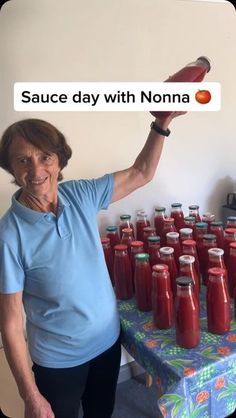 an older woman standing in front of a table full of jars of sauce with the words sauce day with nonna on it