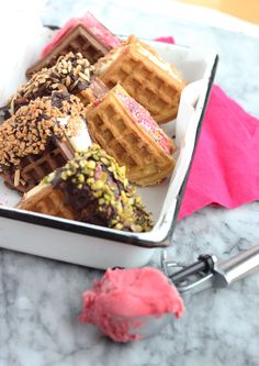 waffles and ice cream are in a container on a table with a pink napkin