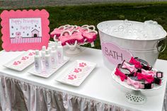 a pink and white birthday party set up on a table