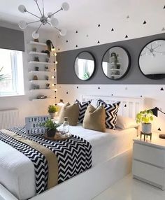 a bedroom with three round mirrors on the wall and two black and white bedspreads