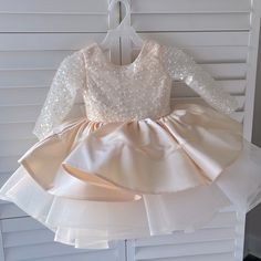 I Bought This Dress For My Granddaughter For A Wedding. It Was Supposed To Be Champagne And For A 2t. I Came And Was More Of A Peacy Then The Tan Look We Were Hoping For. Also It Fit A Little Larger. My Other Granddaughter Is A Size 3t And It Fit Her Perfect. The Dress Is Brand New. Never Worn Other Than Trying On. Great Condition Fitted Long Sleeve Baptism Dress, Fitted Cream Princess Dress For Pageant, Fitted Cream Princess Dress For Pageants, Long Sleeve Ruffled Tutu Dress For Baptism, Cream Fitted Princess Dress For Pageant, Cream Fitted Princess Dress For Dress-up, Fitted Cream Tutu Dress With Ruffles, Cream Princess Dress For Pageants, Long Sleeve Tutu Dress With Ruffles For Pageant