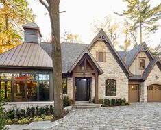 a large brick house with lots of windows and stone walkway leading to the front door