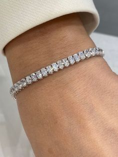 Nyla 11 Carats Oval Cut Diamond Single Row Tennis Bracelet in 18k White Gold Style: Diamond Single Row BraceletDiamondsDiamond Size: 10.79 Carats Diamond Shape: Oval CutSettingMetal: 18K White GoldClasp: Box catch with hidden safetyTotal Carat Weight: 10.79 Carats Luxury Elegant Oval Diamond Bracelet, Luxury Diamond Bracelet With Oval Links, Luxury White Gold Oval Bracelets, Luxury Oval Link Tennis Bracelet For Formal Occasions, Luxury Classic Diamond Bracelet With Oval Link, Luxury White Gold Oval Diamond Bracelet, Luxury Oval Hallmarked Bracelets, Luxury Jeweled White Sterling Silver Bracelet, Diamond Oval Link Bracelet As Gift