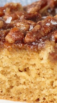 a close up of a piece of cake on a white plate with brown sugar and nuts