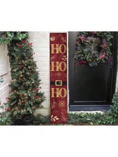 christmas decorations and wreaths are on display in front of a door with a holiday sign