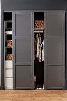 an open closet with clothes and baskets in it