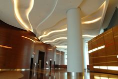 an empty lobby with columns and lights on the ceiling