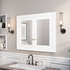 a bathroom with a sink, mirror and lights on the wall above it is shown