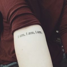 a person with a tattoo on their arm that says, i am, i am