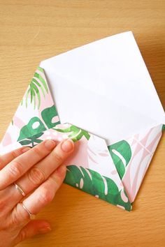 a person is holding an envelope with a piece of paper in it and the other hand