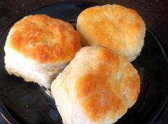 three biscuits sitting on top of a black plate