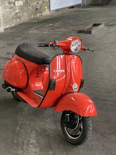 a red scooter parked in an empty parking lot