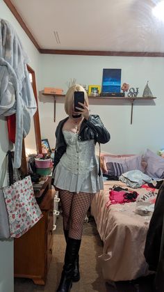 a woman is taking a selfie in her bedroom while wearing tights and boots