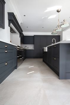 an empty kitchen with black cabinets and white counter tops, is pictured in this image