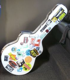 a white guitar with many stickers on it