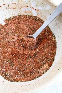 a spoon in a bowl filled with spices