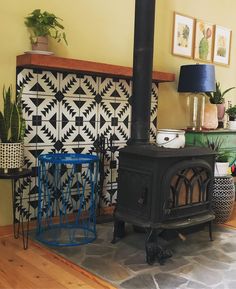 a living room with a wood stove and potted plants