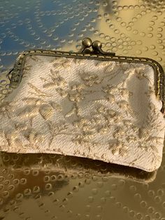 a white purse sitting on top of a table covered in drops of water and bubbles