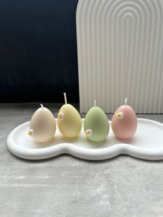 three small birds sitting on top of a white plate next to a radiator