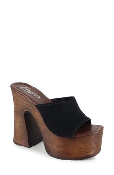 A woodgrain platform and soaring block heel lend scene-stealing height and retro-cool appeal to a slide sandal that will elevate your trendsetting looks. 4" heel; 2" platform Leather upper and lining/synthetic sole Made in Spain Black Chunky Platform Clogs For Summer, Trendy Wedge Sandals With Wooden Block Heel, Trendy Open Toe Clogs With Wooden Heel, Summer Wooden Stacked Heel Heels, Wooden Heels With Stacked Heel For Spring, High Heel Wooden Clogs For Summer, Summer Open Heel Wooden Heels, Summer Open Toe Wood Heels, Wooden Open Toe Heels For Spring