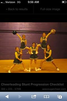 a group of cheerleaders standing in front of a purple wall holding their hands up