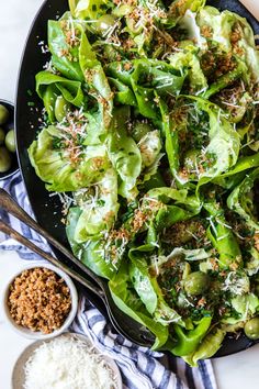 lettuce salad with parmesan cheese and olives in a black bowl