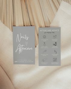 two business cards sitting on top of a white cloth covered bed sheet with the words mais aftercare