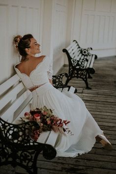 a woman in a white dress sitting on a bench