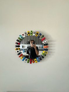 a woman taking a selfie in front of a mirror with colorful cars on it