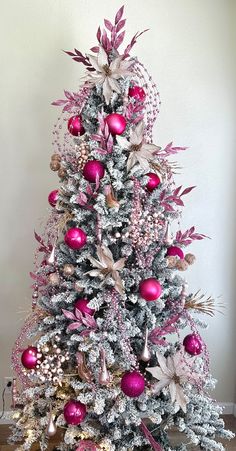 a decorated christmas tree with pink and silver ornaments