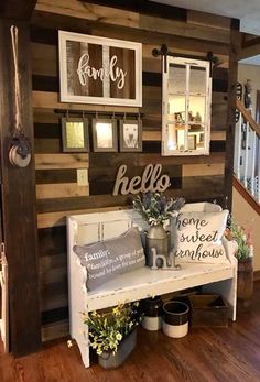 a bench with some plants and pictures on the wall behind it in a room that is decorated with wood planks