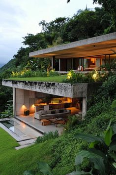 an outdoor living area with grass on the roof and stairs leading up to the upper level