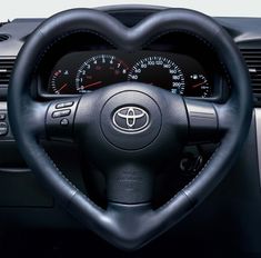 the interior of a car with steering wheel and gauges