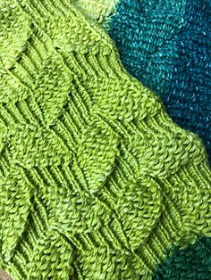 four different colors of knitted fabric on top of each other, one is green and the other is blue