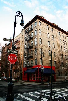 a street corner with a stop sign in front of an apartment building on the corner