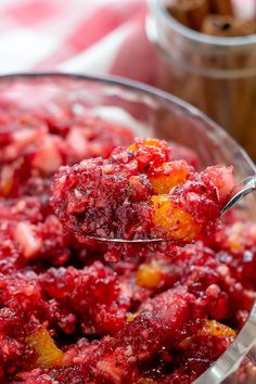 a spoon full of cranberry sauce on top of a bowl