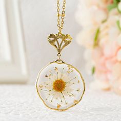 "Handmade real birth flower necklace featuring a dried pressed Daisy flower pendant. The birth flower is adorned with Queen Anne's lace and gold flakes. The beautiful dried flower pendant is embedded in a UV resin 32mm (1.26 inch) round irregular setting and is available in a gold or silver finish. The high quality stainless steel beaded chain is enhanced by a Victorian style floral bail. You can choose your chain length between 18\", 20\", 24\", 30\" inches. Your jewelry will arrive in a lovely Flower Shaped Necklaces With Pressed Flowers For Mom, Pressed Flower Jewelry For Mom, Pressed Flower Jewelry As A Gift For Mom, Round Pendant Flower Necklace As Gift For Her, Flower Shape Necklace With Pressed Flowers For Mom, Pressed Flower Jewelry Gift For Mom, Handmade Gold Flower Necklace, Birth Flower Necklace Keepsake, White Necklaces With Pressed Flowers For Mom