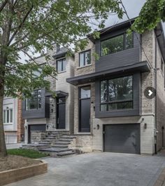 the front of a two story house with stairs leading up to it's garage