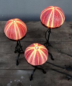 three lamps sitting on top of a wooden table