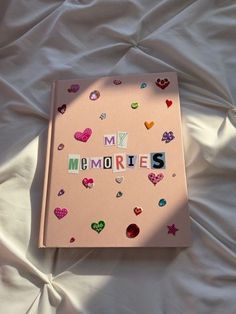 a pink book with the word my memories written on it and lots of small hearts