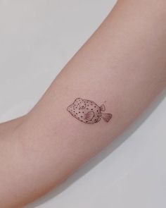 a small fish tattoo on the arm