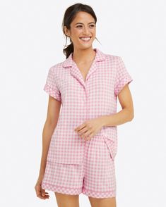 On cloud 9. The Sara Pajama Set in pink ginghamis as comfortable as it is pretty. Constructed from a lush luxe knit, this fabric feels ultra soft and buttery to the touch. Designed with an easy fit, this romper features a playful stripe print, functional buttons, and an adjustable drawstring at the waist. Cue up your streaming service and get ready to snuggle for hours on end========93%Viscose, 7% Spandex; Top Length: 24.5", Shorts Inseam: 3"| Extended Top Length: 28", Shorts Inseam: 4.5"; Short Cute Pjs, British Women, Spandex Top, Draper James, Gingham Tops, Cute Pajamas, Pink Gingham, Pajama Party, Pajama Top