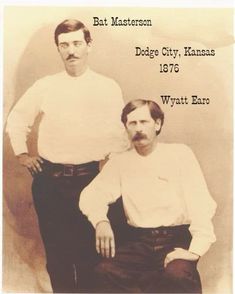 an old photo of two men in white shirts and black pants, one with a mustache