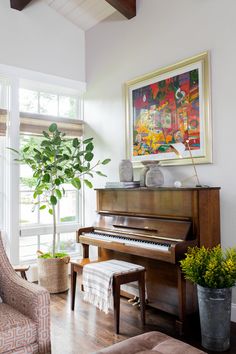 a living room filled with furniture and a large painting on the wall above a piano