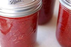 three jars filled with red liquid sitting on top of a table