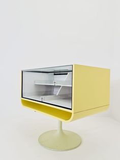 an empty yellow shelf on top of a white table