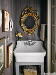 a white sink sitting under a mirror next to a wall mounted faucet in a bathroom