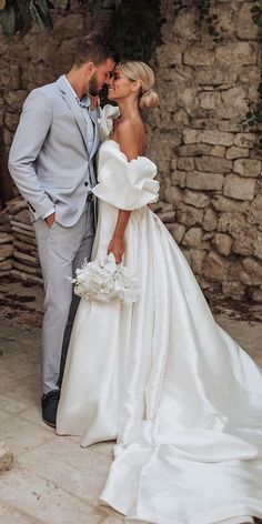 a bride and groom posing for a wedding photo