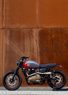 a motorcycle parked in front of a rusted wall