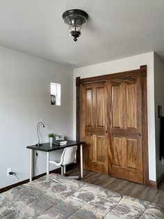 a bed room with a neatly made bed and two wooden doors